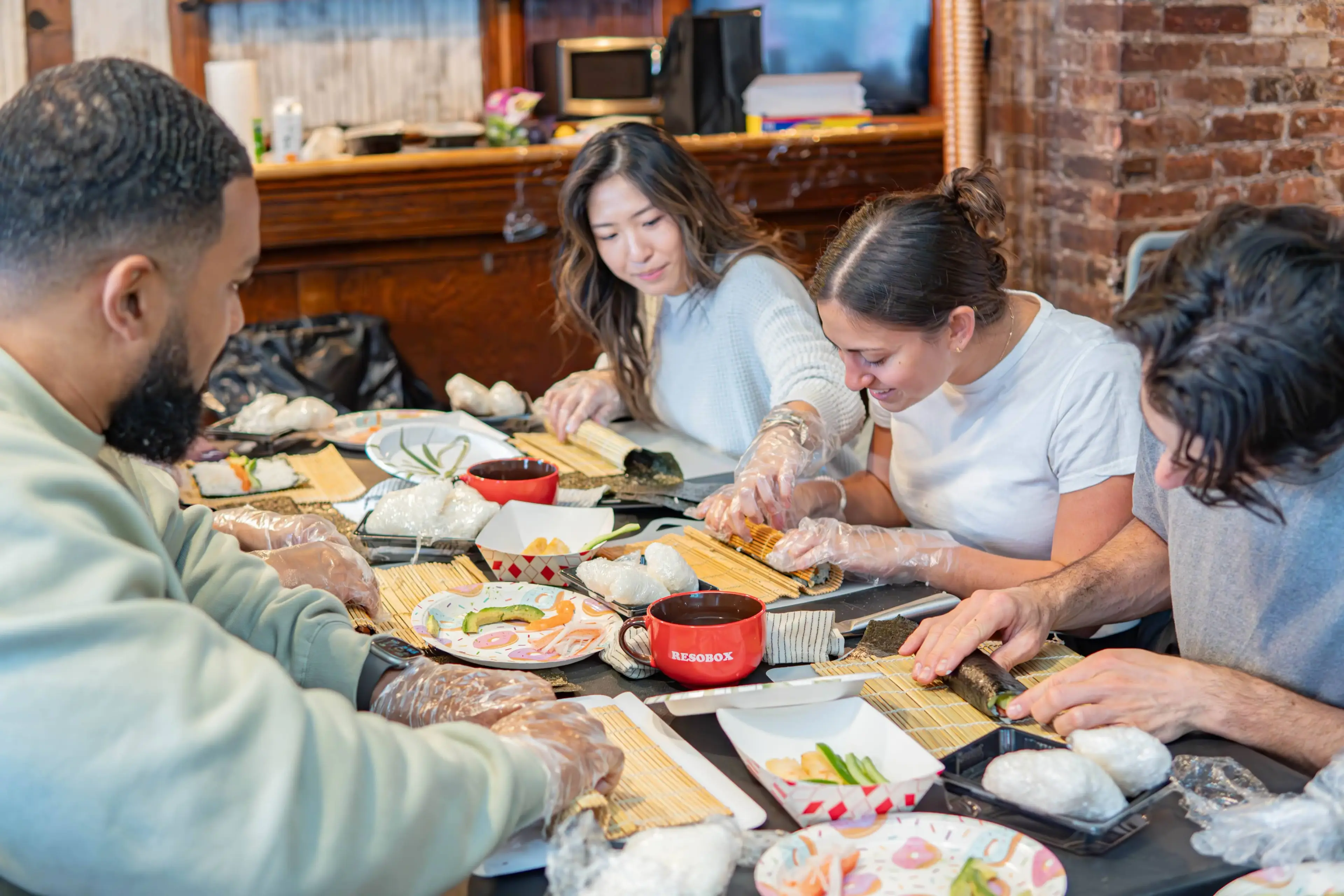 Coworkers learning to make sushi together